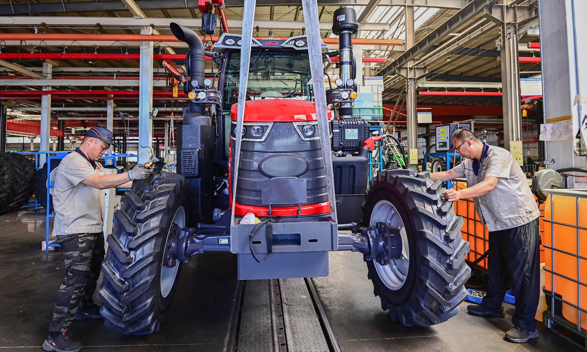 Workers assemble a tractor at a plant in Qingdao, East China's Shandong Province on June 27, 2025. In the first five months, profits in China's equipment manufacturing sector rose 7.2 percent year-on-year, providing significant support to the overall industrial profit structure, according to the National Bureau of Statistics.