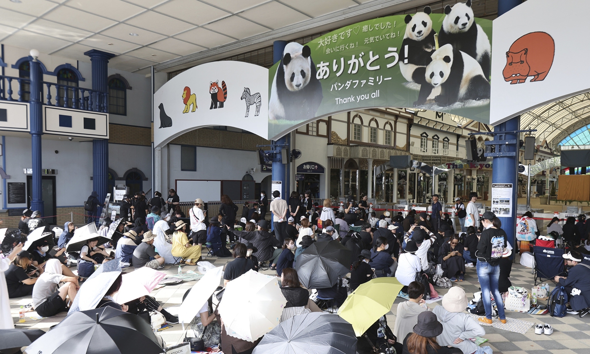 People line up before the opening of the theme park 