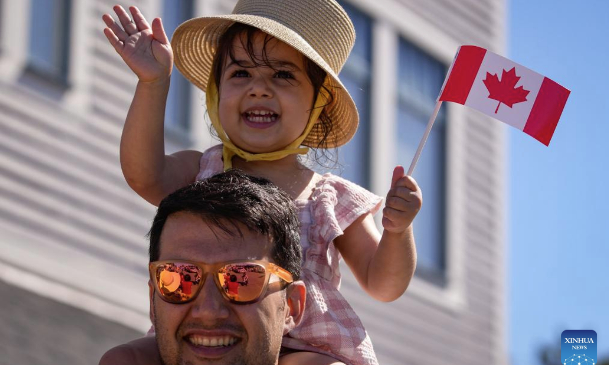 A girl holds a flag during a Canada Day Parade in Richmond, British Columbia, Canada, on July 1, 2025. (Photo by Liang Sen/Xinhua)