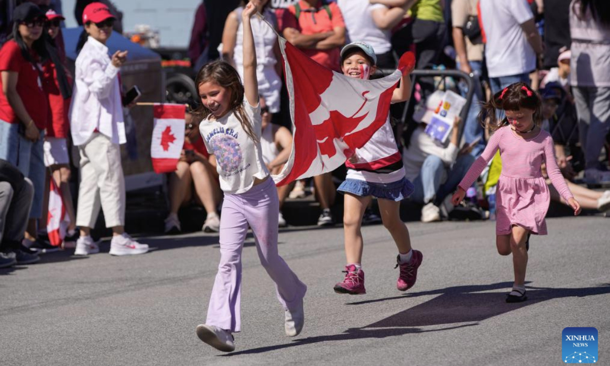 Children run with a flag during a Canada Day Parade in Richmond, British Columbia, Canada, on July 1, 2025. (Photo by Liang Sen/Xinhua)
