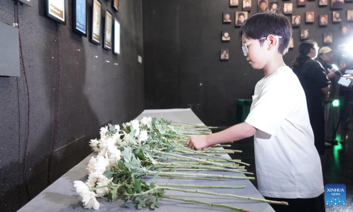 Sun Guoting, descendant of the Nanjing Massacre survivor Liu Guixiang, lays a flower during a lights out ceremony held at the Memorial Hall of the Victims in Nanjing Massacre by Japanese Invaders in Nanjing, east China's Jiangsu Province, July 2, 2025. A lights out ceremony for two survivors of the Nanjing Massacre who passed away this year was held here on Wednesday. On a photo wall featuring survivors of the Nanjing Massacre, the lightboxes of Liu Guixiang and Xie Guiying were dimmed off, and their colored photos then turned to black and white.

With the passing away of Liu and Xie earlier this year, the number of living registered survivors has decreased to 26. (Photo by Liu Zhenrui/Xinhua)