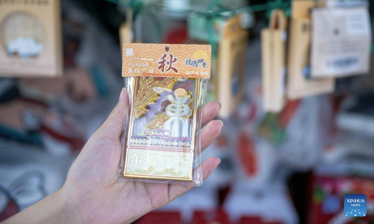 A visitor holds a fridge magnet during an event themed with Wurigong in the Hezhe ethnic village of Zhuaji in Wusu Town of Fuyuan City, northeast China's Heilongjiang Province, July 1, 2025. The Hezhe are one of the less populous ethnic groups in China, residing along the Heilongjiang, Songhuajiang and Wusuli rivers. Due to their location in the east, they are known as the sun watchers.

Wurigong means joy and celebration in the language of the Hezhe ethnic group. The event serves as a showcase of Hezhe culture, combining traditional music, dance, narrative art and sports. (Xinhua/Zhang Tao)