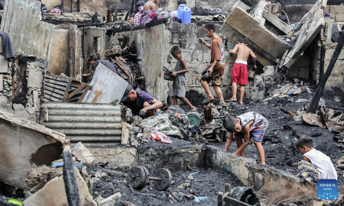 Residents search for their belongings as they return to their charred homes after a fire at a slum area in Manila, the Philippines, July 2, 2025. (Xinhua/Rouelle Umali)