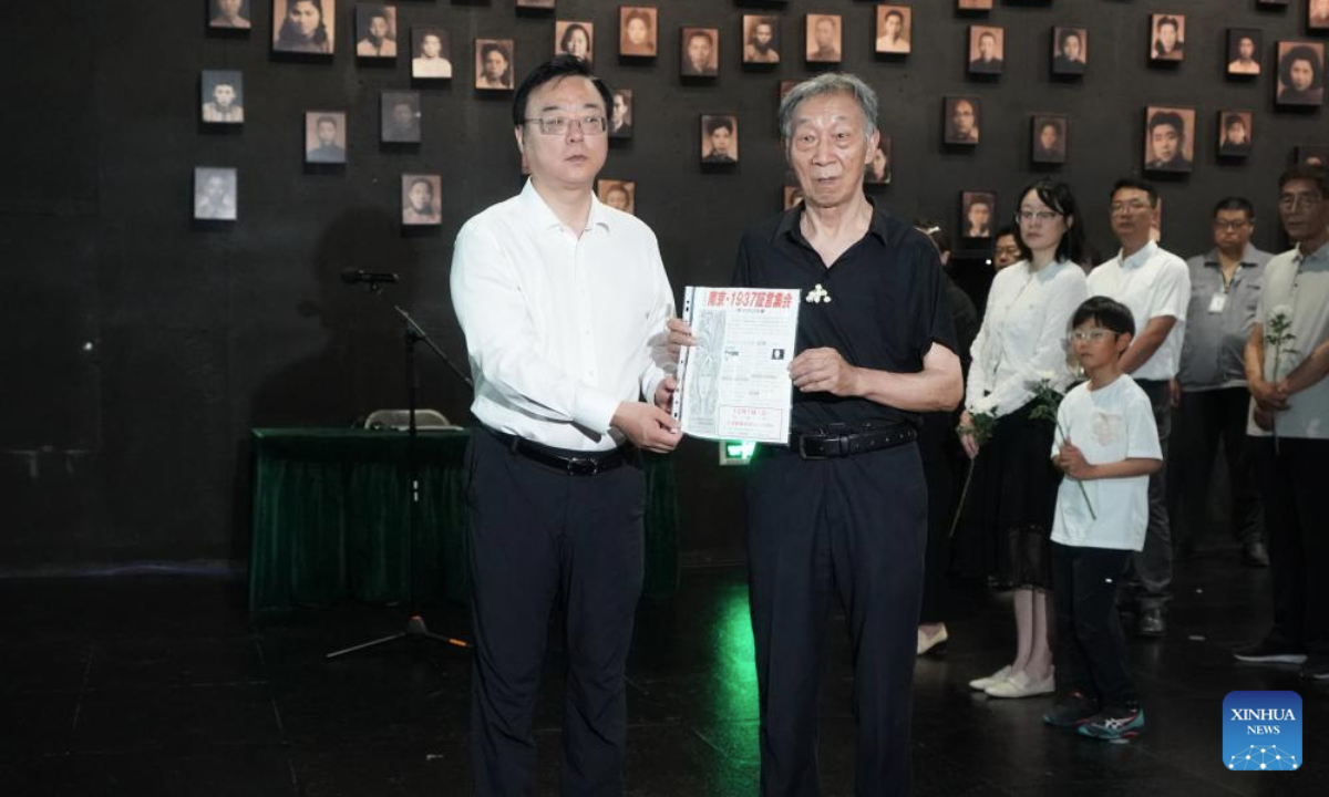 Jiang Zhongrong (R), son of the Nanjing Massacre survivor Xie Guiying, donates an item belonging to Xie to the Memorial Hall of the Victims in Nanjing Massacre by Japanese Invaders in Nanjing, east China's Jiangsu Province, July 2, 2025. A lights out ceremony for two survivors of the Nanjing Massacre who passed away this year was held here on Wednesday. On a photo wall featuring survivors of the Nanjing Massacre, the lightboxes of Liu Guixiang and Xie Guiying were dimmed off, and their colored photos then turned to black and white.

With the passing away of Liu and Xie earlier this year, the number of living registered survivors has decreased to 26. (Photo by Liu Zhenrui/Xinhua)