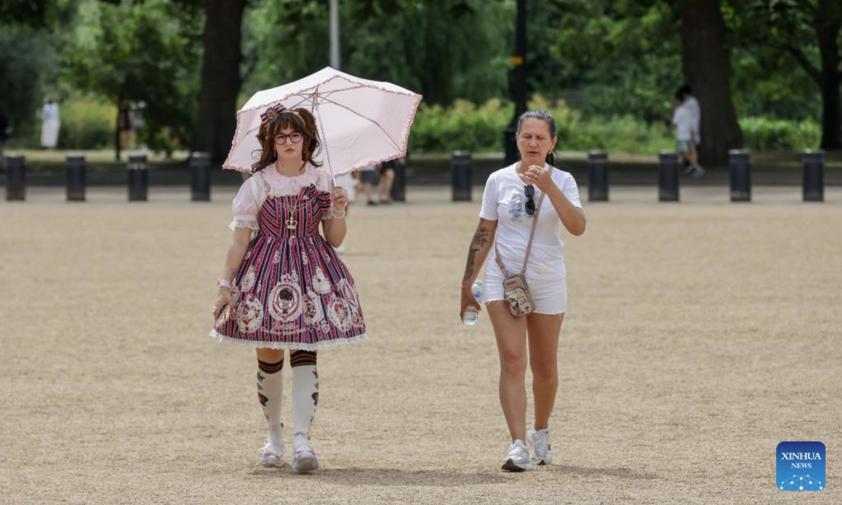 A woman shelters under an umbrella as heatwave continues in London, Britain, July 1, 2025. The UK Health Security Agency (UKHSA) extended amber heat health alerts for much of the country this week. (Xinhua)
