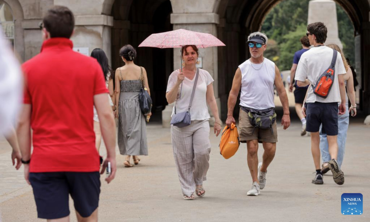 A woman shelters under an umbrella as heatwave continues in London, Britain, July 1, 2025. The UK Health Security Agency (UKHSA) extended amber heat health alerts for much of the country this week. (Xinhua)
