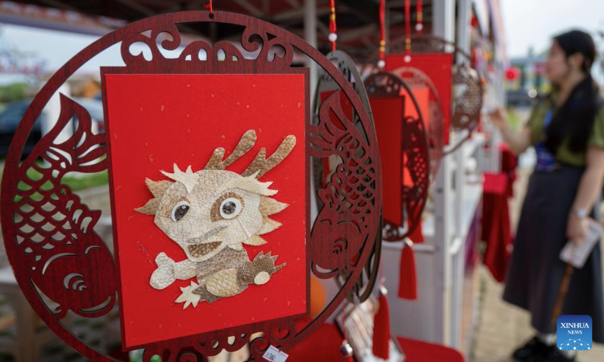 Visitors look at fish skin handicrafts during an event themed with Wurigong in the Hezhe ethnic village of Zhuaji in Wusu Town of Fuyuan City, northeast China's Heilongjiang Province, July 1, 2025. The Hezhe are one of the less populous ethnic groups in China, residing along the Heilongjiang, Songhuajiang and Wusuli rivers. Due to their location in the east, they are known as the sun watchers.

Wurigong means joy and celebration in the language of the Hezhe ethnic group. The event serves as a showcase of Hezhe culture, combining traditional music, dance, narrative art and sports. (Xinhua/Zhang Tao)