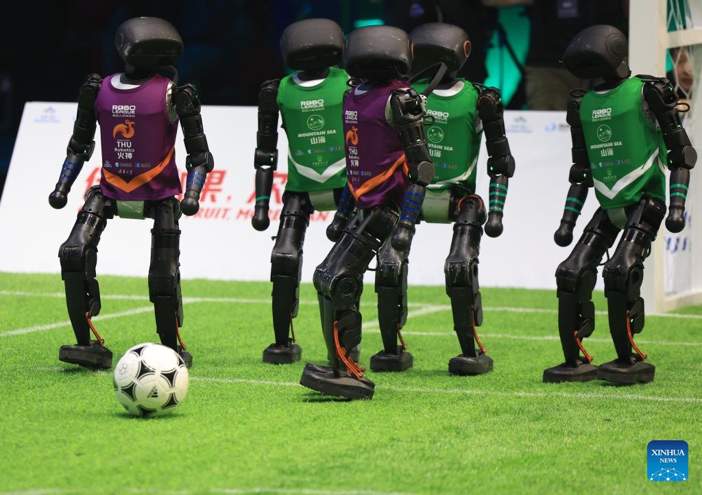 Robot players of the THU Robotics team from Tsinghua University compete with their counterparts of the Mountain Sea team from China Agricultural University during an AI-powered robot football match in Beijing, capital of China, June 28, 2025. A 3v3 robot football match, where all players were autonamous via artificial intelligence, concluded here Saturday. Four teams from three Chinese universities competed in the match, and the championship was garnered by the THU Robotics team from Tsinghua University. (Photo: Xinhua)