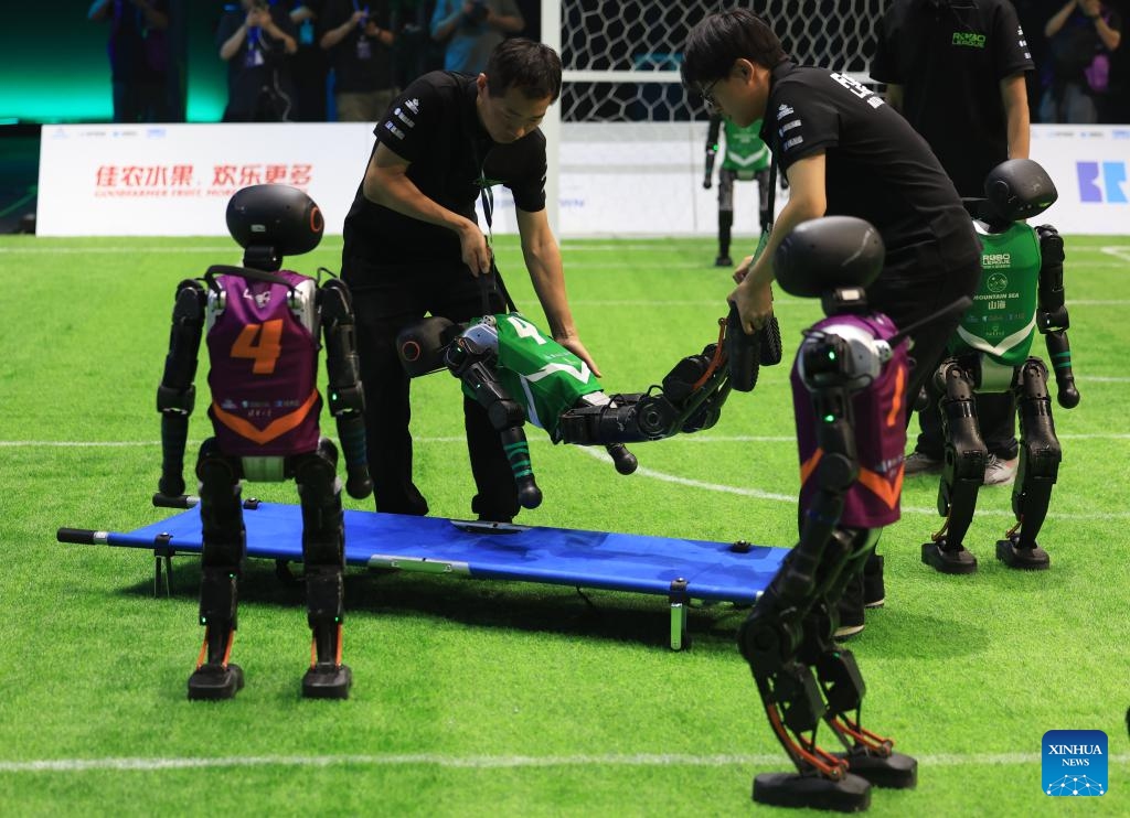 A robot player of the Mountain Sea team from China Agricultural University is carried away on a stretcher during an AI-powered robot football match in Beijing, capital of China, June 28, 2025. A 3v3 robot football match, where all players were autonamous via artificial intelligence, concluded here Saturday. Four teams from three Chinese universities competed in the match, and the championship was garnered by the THU Robotics team from Tsinghua University. (Photo: Xinhua)