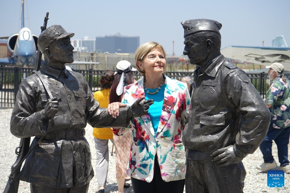 Nell Calloway poses for photos alongside the sculptures in Los Angeles, the United States, on June 28, 2025. A ceremony unveiling sculptures of Flying Tigers was held on Saturday to commemorate the 80th anniversary of the victory in the Chinese People's War of Resistance Against Japanese Aggression and the World Anti-Fascist War. (Photo: Xinhua)