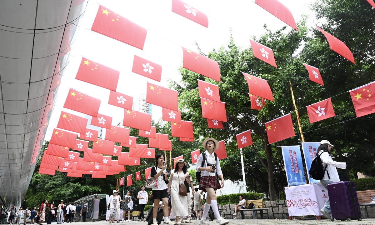 People walk on a street decorated with the national flag of China and the Hong Kong Special Administration Region's flag in the city on July 1, 2025. The day marks the 28th anniversary of the region's return to the motherland on July 1, 1997. Photo: cnsphoto