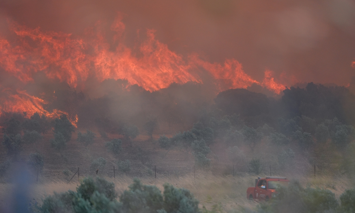 Flames and smoke rise from burning trees and bushes while air and land intervention continues against a fire that broke out in the maquis shrubland and spread rapidly due to the wind in Izmir, Turkey, on July 1, 2025. Photo: VCG