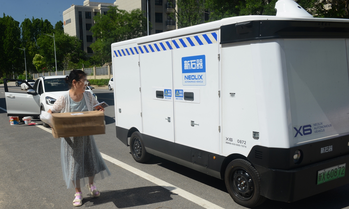A community station staff member receives goods delivered by an autonomous delivery vehicle in Zhengzhou, Central China's Henan Province, on July 3, 2025. Photo: VCG