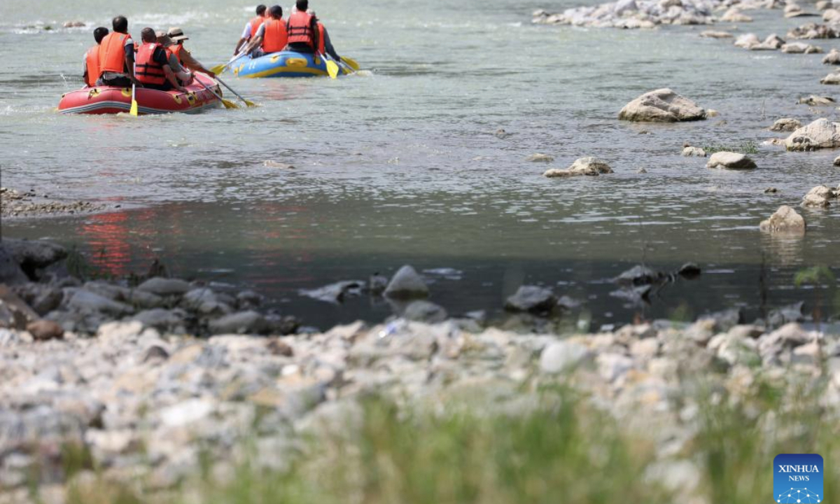 People raft in inflatable boats on Jiangling River in Huixian County, northwest China's Gansu Province, July 15, 2025. (Xinhua/Chen Bin)