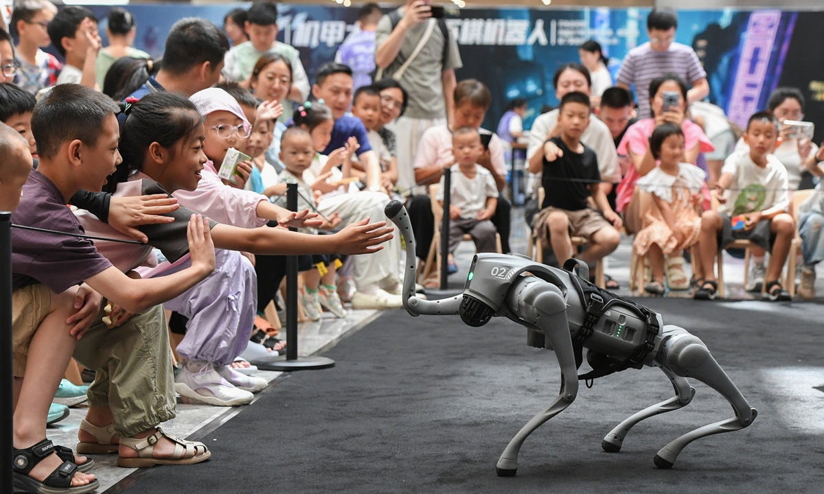 Children interact with robot dogs at an exhibition on artificial intelligence-equipped robots in Jinhua, East China's Zhejiang Province on July 6, 2025. Photo: VCG