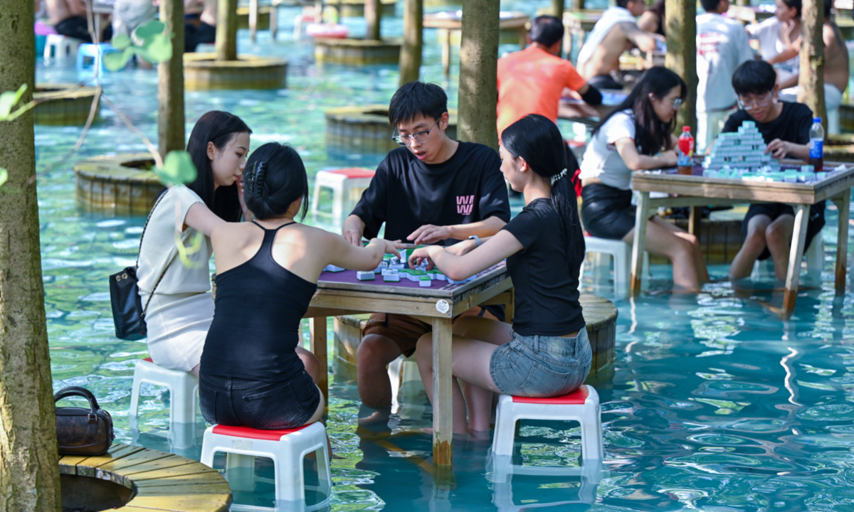 Residents soak their feet while playing mahjong at an aquatic park in Chengdu, Southwest China’s Sichuan Province, on July 23, 2025, seeking respite from the recent heatwave. Photo: VCG