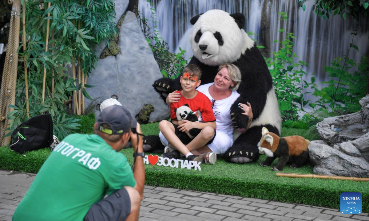 Visitors pose for photos with a giant panda doll at the Moscow Zoo in Moscow, Russia, on July 30, 2025. The Moscow Zoo held an event to celebrate giant panda Dingding's eighth birthday on Wednesday. (Photo by Alexander Zemlianichenko Jr/Xinhua)