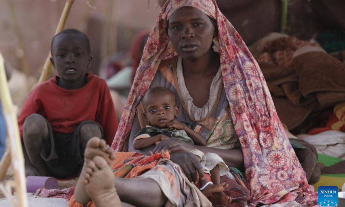 A woman holds a child at a displacement camp in El Fasher, North Darfur region, Sudan, on July 9, 2025. The United Nations Children's Fund (UNICEF) said Friday that the number of children suffering from severe acute malnutrition (SAM) in Sudan's North Darfur region has doubled as a result of the country's ongoing military conflict. (UNICEF/Handout via Xinhua)