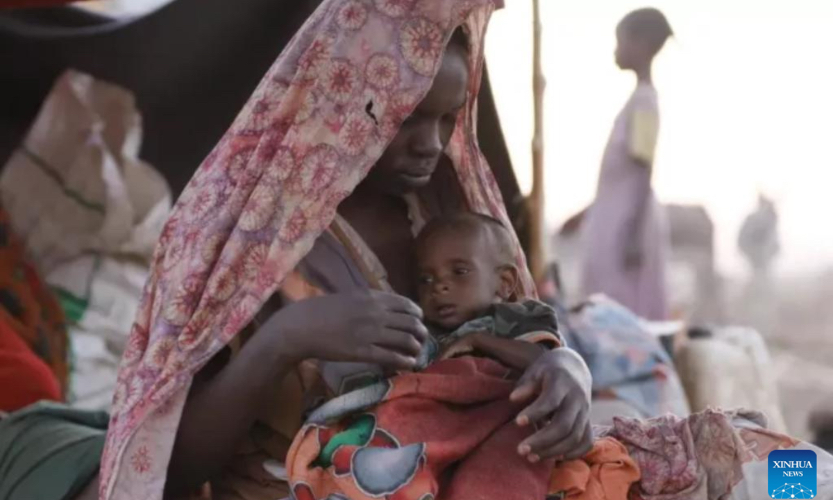 A woman holds a child at a displacement camp in El Fasher, North Darfur region, Sudan, on July 9, 2025. The United Nations Children's Fund (UNICEF) said Friday that the number of children suffering from severe acute malnutrition (SAM) in Sudan's North Darfur region has doubled as a result of the country's ongoing military conflict. (UNICEF/Handout via Xinhua)