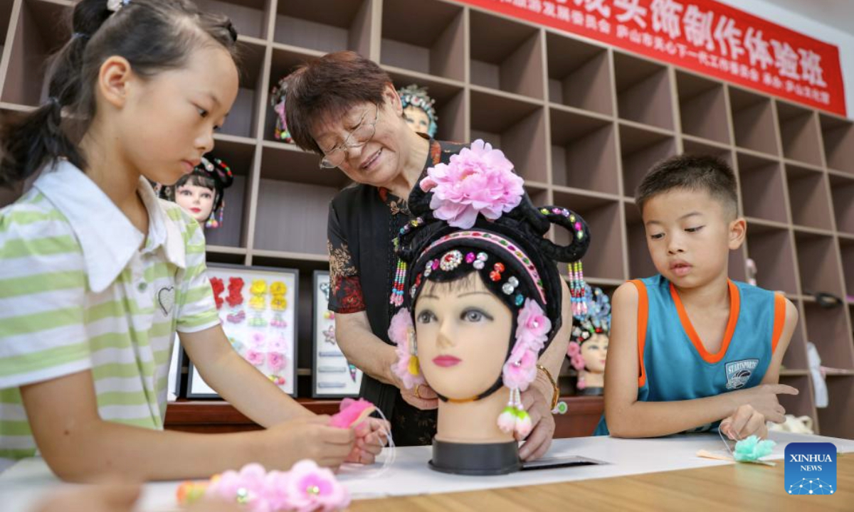 Pupils learn to make traditional Chinese headwear at a cultural center in Lushan City, east China's Jiangxi Province, July 8, 2025. Children across the country are enriching their summer vacations through colorful activities. (Photo by Han Junxuan/Xinhua)