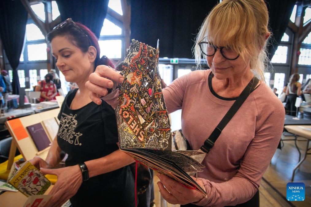 A visitor checks out a DIY art book during the 2025 Vancouver Art Book Fair in Vancouver, British Columbia, Canada, July 4, 2025. The three-day event, which kicked off here on Friday and runs through July 6, features nearly 100 exhibitors showcasing artist books, zines, and other independent publications. (Photo: Xinhua)