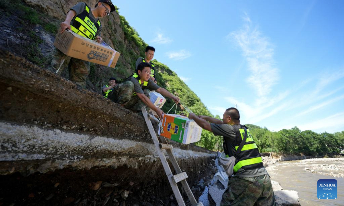 Rescuers deliver relief supplies to affected villagers in Sanchakou Village of Fengjiayu Town, Miyun District of Beijing, capital of China, July 30, 2025. Due to continuous heavy rainfall in recent days, hundreds of villages in multiple districts of Beijing have been affected. In some villages of Fengjiayu Town, Miyun District, the roads have not yet been restored. Relevant departments have organized multiple rescue forces including firefighters and militiamen to transport relief supplies on foot to the villages to ensure the living needs of the affected villagers. (Xinhua/Ju Huanzong)