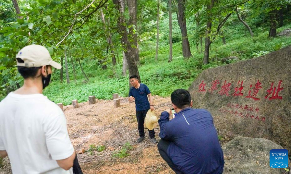 Meng Qingxu, leader of the Hongshilazi Site excavation team, introduces a historical site at the ancient forests of Hongshilazi in Panshi City, northeast China's Jilin Province, June 26, 2025. (Xinhua/Yan Linyun)