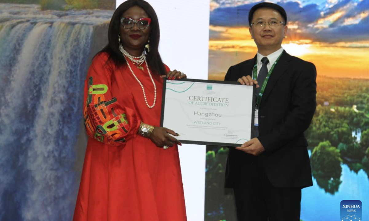 Musonda Mumba (L), secretary general of the Convention on Wetlands, hands over an international wetland city certificate of accreditation to a representative from Hangzhou, east China's Zhejiang Province, in Victoria Falls, Zimbabwe, on July 24, 2025. A total of nine Chinese cities were accredited as international wetland cities on Thursday during the opening of the 15th Meeting of the Conference of the Contracting Parties to the Ramsar Convention on Wetlands (COP15) held in Victoria Falls, bringing the total number of such cities in China to 22, the highest in the world. (Xinhua/Tafara Mugwara)