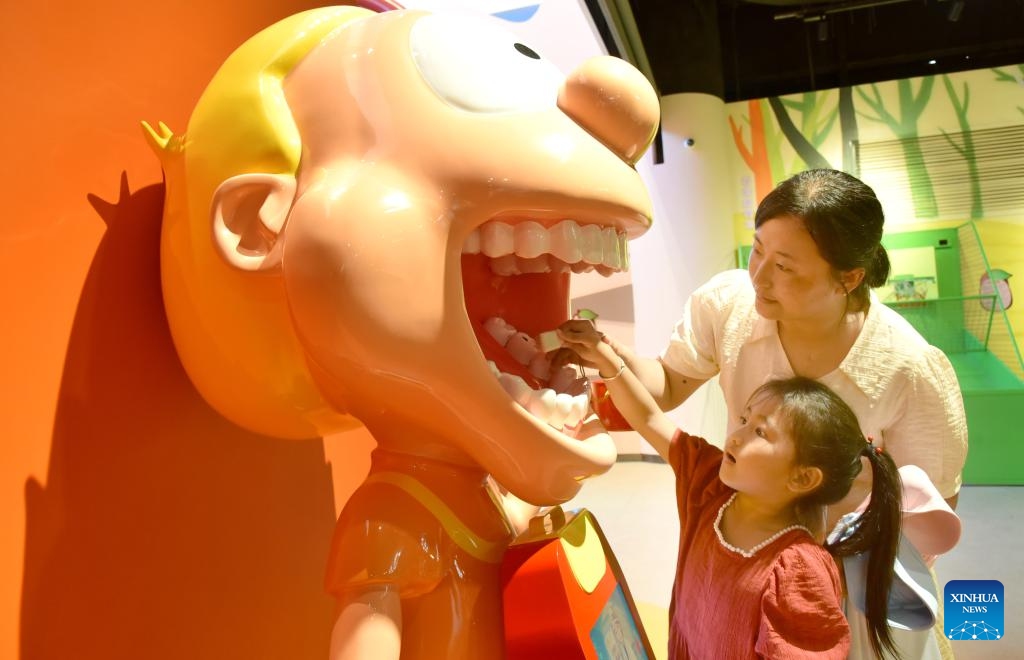 A child learns to brush teeth through a human oral model at a science and technology museum in Zaozhuang City, east China's Shandong Province, July 5, 2025. (Photo: Xinhua)