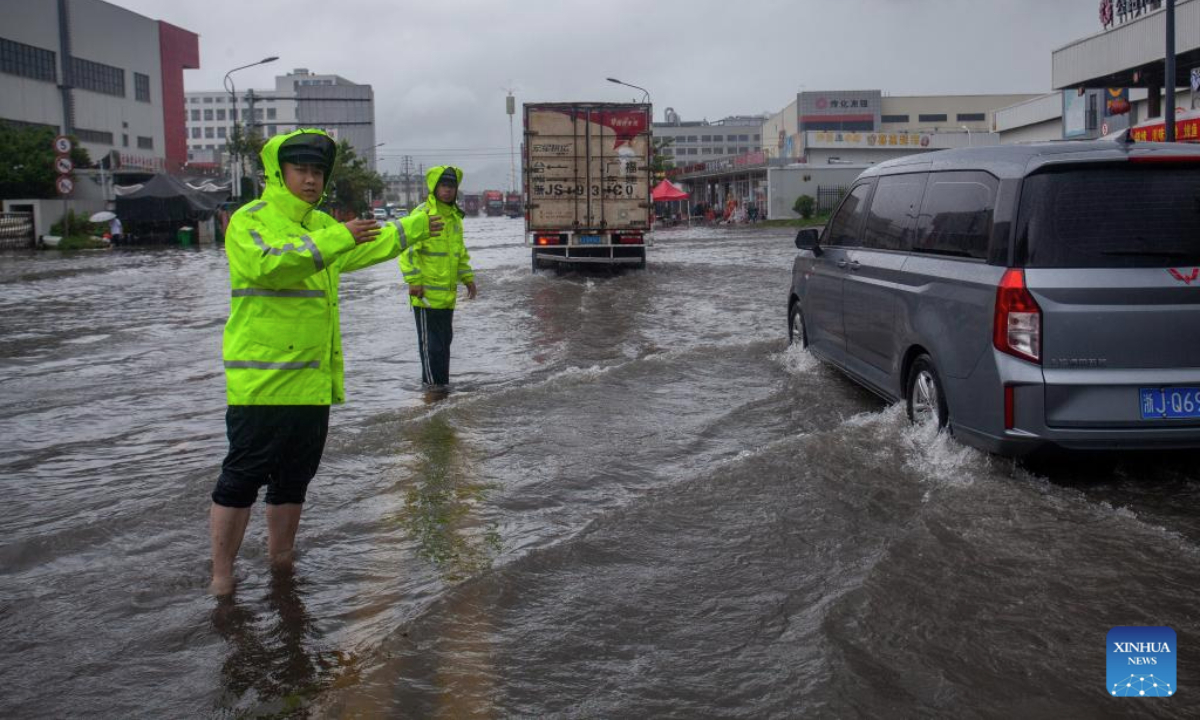 Police officers are pictured on duty on a waterlogged road in Huangyan District of Taizhou, east China's Zhejiang Province, July 8, 2025. China's Ministry of Water Resources on Monday activated a Level-IV emergency response to flooding in the eastern provinces of Zhejiang and Fujian as Typhoon Danas approaches. (Photo by Yu Yuexiang/Xinhua)