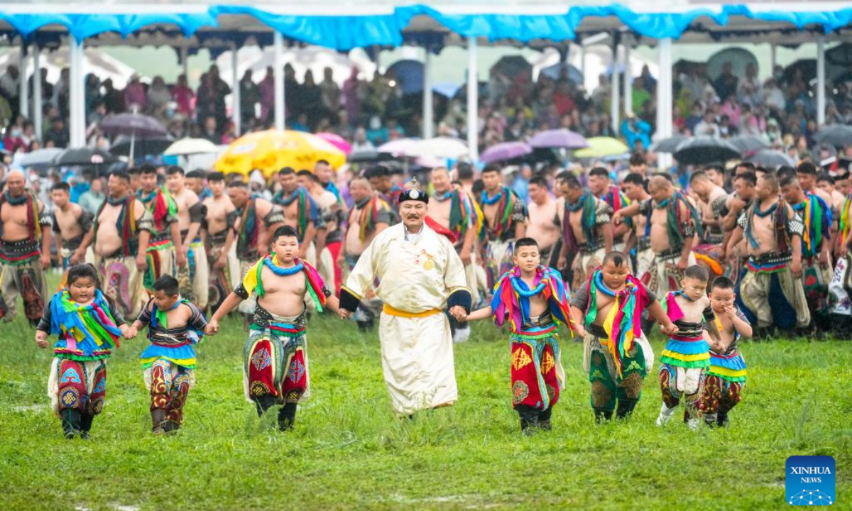 Mongolian wrestlers show off their tradition during the opening ceremony of a Nadam fair held in Xilinhot, Xilin Gol League, north China's Inner Mongolia Autonomous Region, July 19, 2025. The Nadam Fair opened here on Saturday, featuring night parade performances, intangible cultural heritage handicraft making events, and ethnic game experiences. The fair has effectively invigorated the summer tourism market, and attracted tourists to experience the charm of grassland culture. (Xinhua/Ma Jinrui)