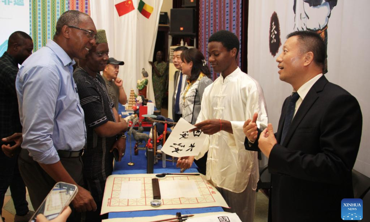 People communicate during a cultural event at the Chinese Cultural Center in Cotonou, Benin's economic capital, July 29, 2025. The event was held here on Tuesday night, offering the Beninese public a deep dive into the heritage of Xi'an, one of China's most historic cities. (Photo by Seraphin Zounyekpe/Xinhua)