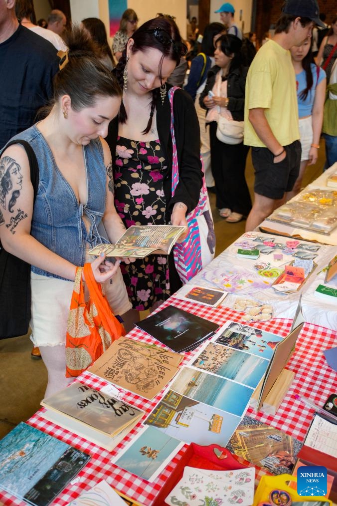 Visitors browse publications during the 2025 Vancouver Art Book Fair in Vancouver, British Columbia, Canada, July 4, 2025. The three-day event, which kicked off here on Friday and runs through July 6, features nearly 100 exhibitors showcasing artist books, zines, and other independent publications. (Photo: Xinhua)