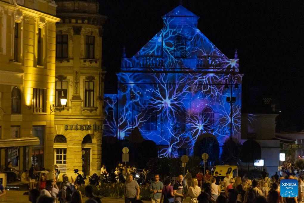 People enjoy a light performance during the Zsolnay Light Festival held in downtown Pecs, Hungary on July 4, 2025. (Photo: Xinhua)
