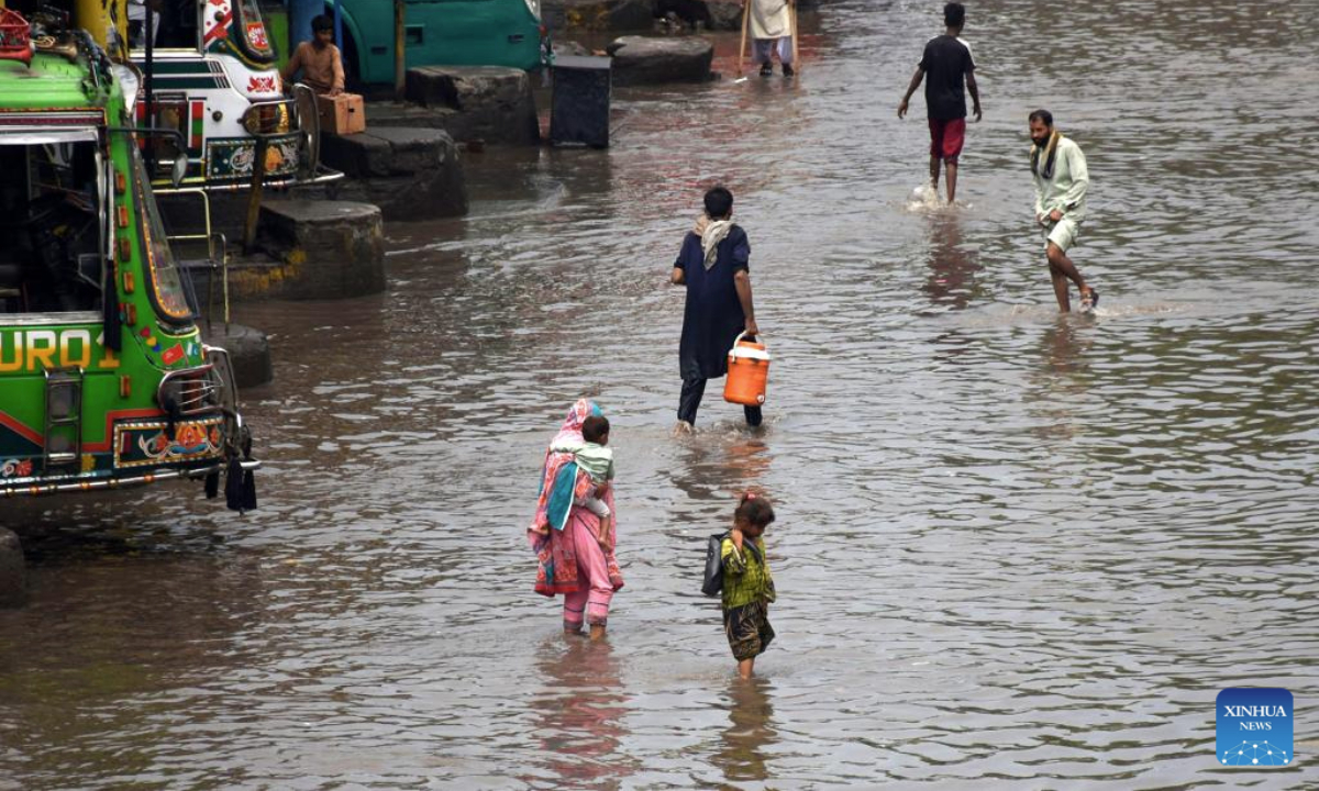 People wade through floodwater in a street after heavy monsoon rain in Lahore, Pakistan on July 9, 2025. (Photo by Sajjad/Xinhua)