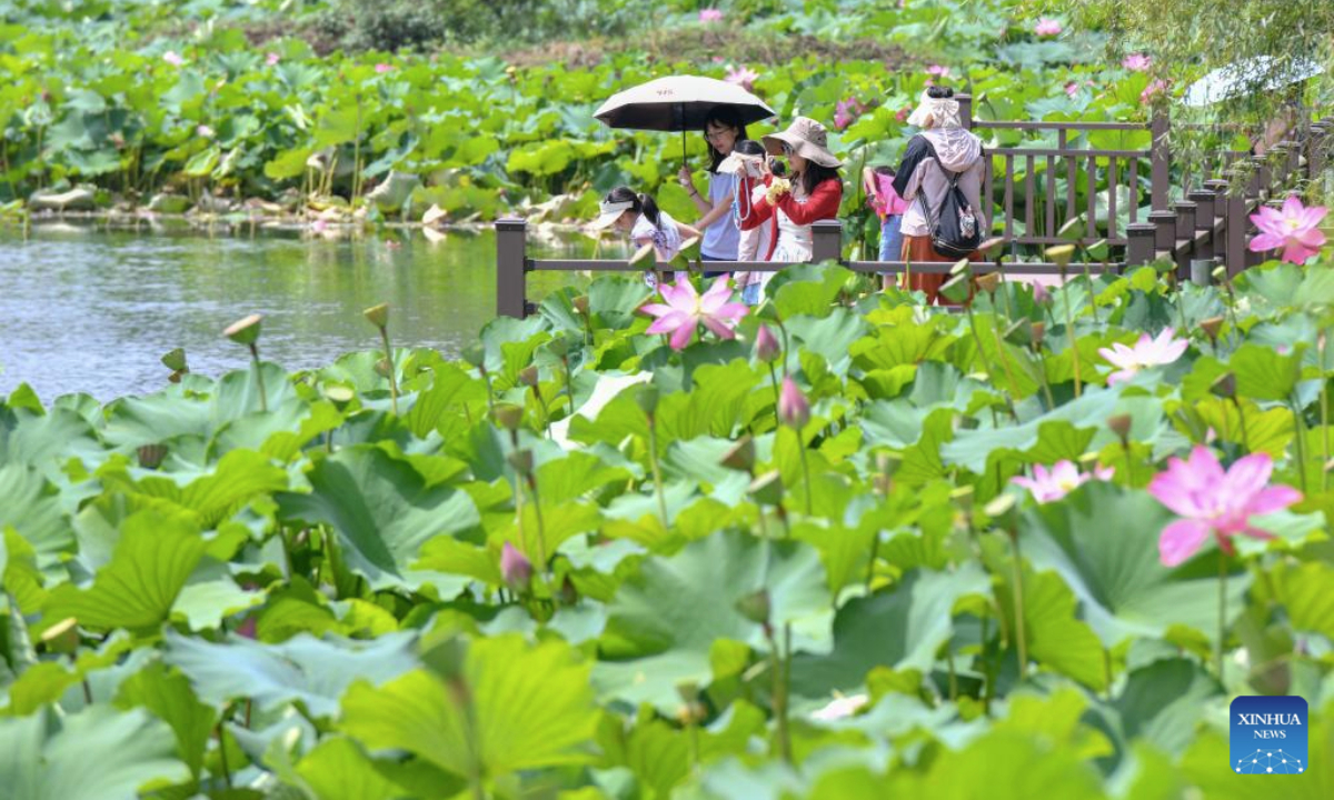 Tourists take photos at the Puzhehei scenic area in Qiubei County, Wenshan Zhuang and Miao Autonomous Prefecture, southwest China's Yunnan Province, July 16, 2025. The beautiful scenery of Puzhehei, along with the rich amusement facilities there, has attracted lots of visitors during the summer. (Photo by Peng Yikai/Xinhua)