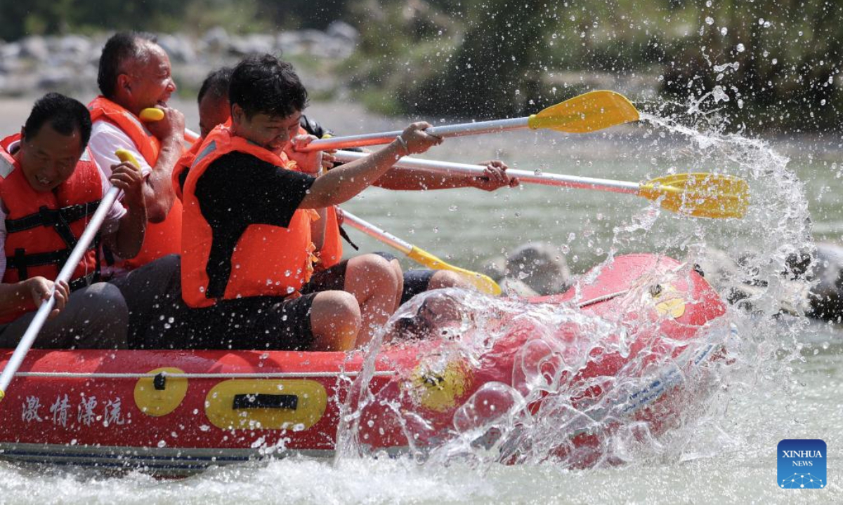 People raft in an inflatable boat on Jiangling River in Huixian County, northwest China's Gansu Province, July 15, 2025. (Xinhua/Chen Bin)