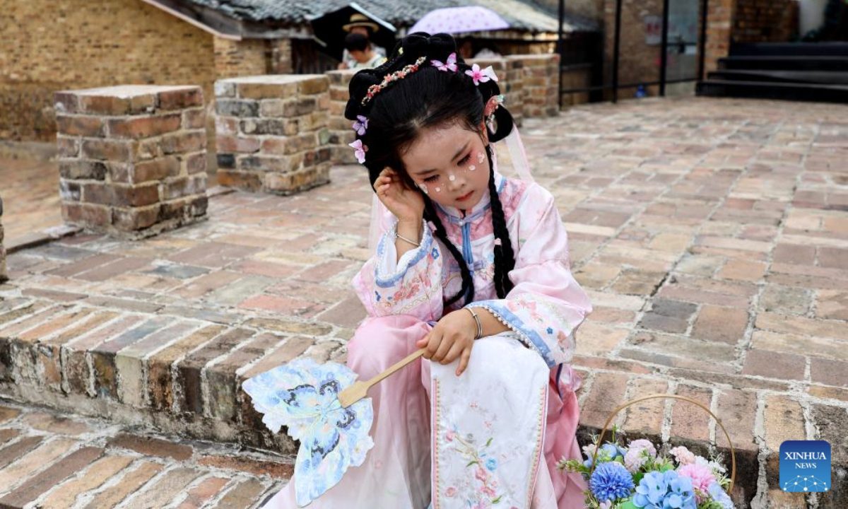 A tourist takes a break at Taoyangli historical and cultural block in Jingdezhen City, east China's Jiangxi Province, July 13, 2025. Located in the heart of Jingdezhen, Taoyangli has successfully transformed from an old district into a thriving hub for cultural innovation and tourism in recent years. Today, it has become a must-visit destination for tourists. (Xinhua/Liu Jinhai)