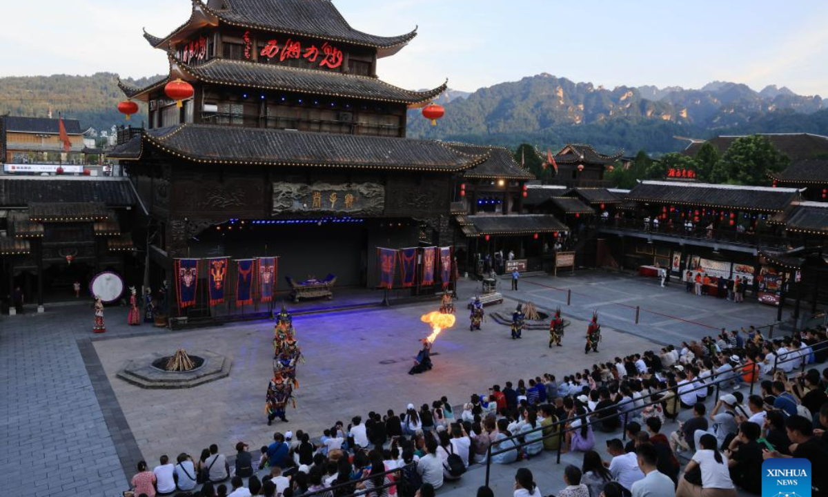 Visitors watch a folk culture performance at Zhangjiajie, central China's Hunan Province, July 26, 2025. (Photo by Wu Yongbing/Xinhua)