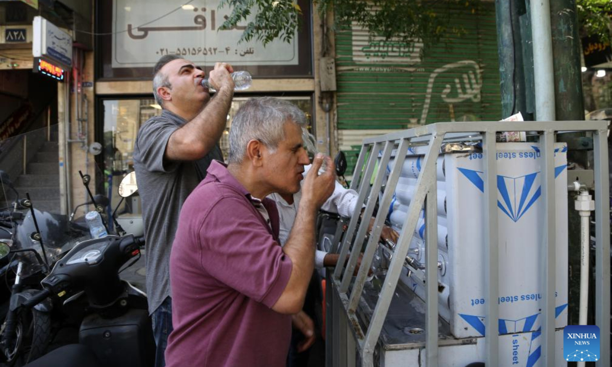 People eat ice cream on a street in Tehran, Iran, July 22, 2025. Unrelenting high temperatures have triggered water and electricity shortages across large parts of Iran, with several cities issuing yellow weather alerts, Iranian media reported on Monday. (Xinhua)