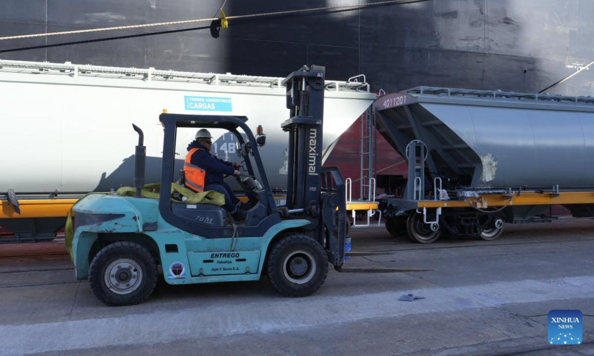 A worker unloads Chinese-made meter-gauge railway grain wagons at a port in Buenos Aires, Argentina, July 30, 2025. A total of 90 Chinese-made meter-gauge railway grain wagons arrived here on Tuesday, which will all be put into an Argentina's railway network to undertake soybean and corn transportation. (Xinhua/Zhang Duo)