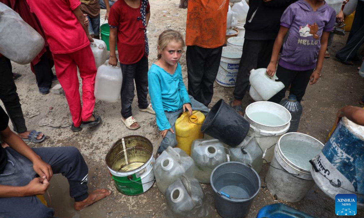 A displaced Palestinian child fetches water at a temporary shelter in Gaza City, on Aug. 1, 2025. (Photo by Rizek Abdeljawad/Xinhua)