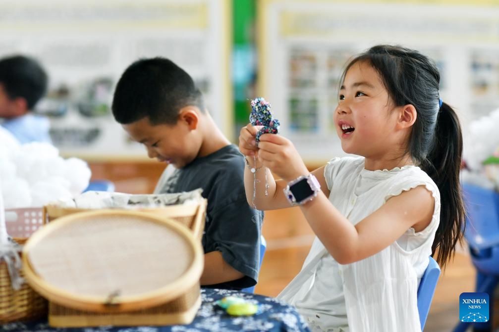 Children learn to make sachets in Qingdao, east China's Shandong Province, July 5, 2025. (Photo: Xinhua)