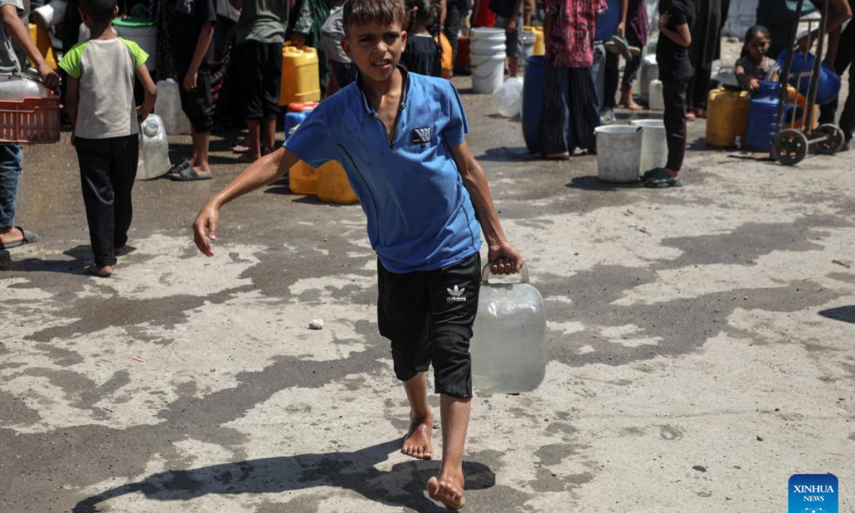 A displaced Palestinian child fetches water at a temporary shelter in Gaza City, on Aug. 1, 2025. (Photo by Rizek Abdeljawad/Xinhua)