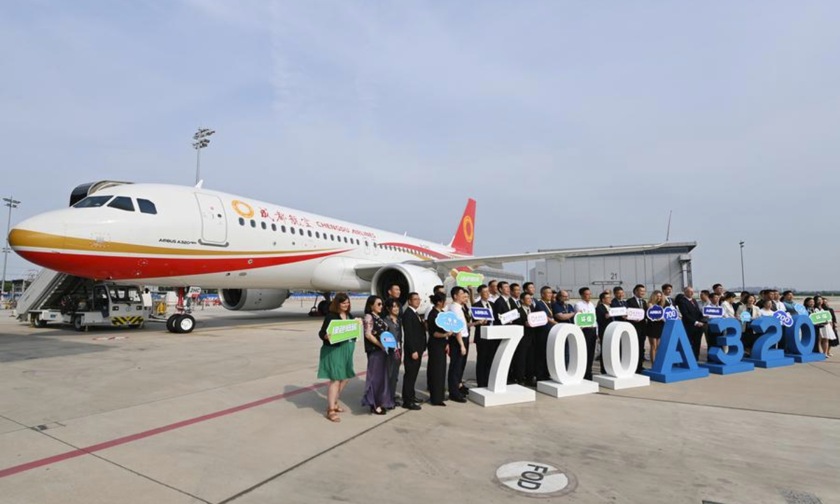 Guests attending the delivery ceremony of the 700th A320 family aircraft assembled by Airbus Tianjin to Chengdu Airlines pose for a group photo in front of the A320neo aircraft in Tianjin, north China, July 8, 2024. (Xinhua/Li Ran)