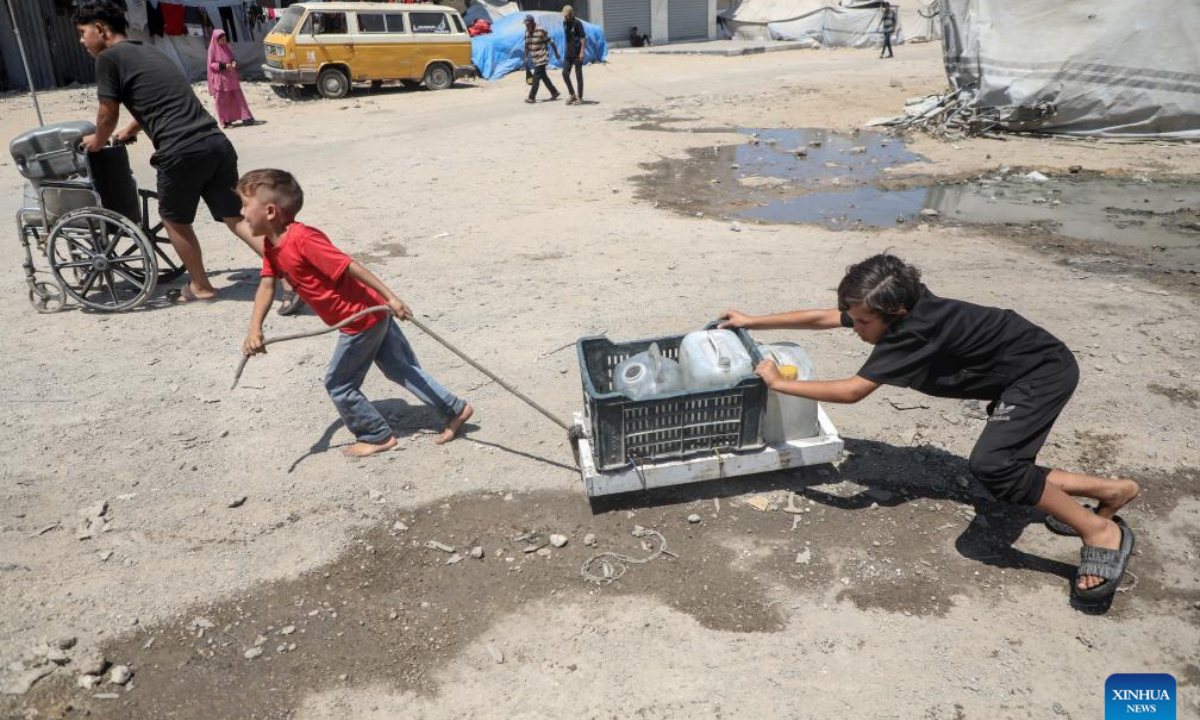 Displaced Palestinian children fetch water at a temporary shelter in Gaza City, on Aug. 1, 2025. (Photo by Rizek Abdeljawad/Xinhua)