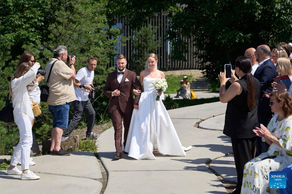 A couple enters a group wedding ceremony at Highland Park in Vladivostok, Russia, July 5, 2025. Three newlywed couples join in a group wedding ceremony here on Thursday, receiving blessings from families and friends. (Photo: Xinhua)