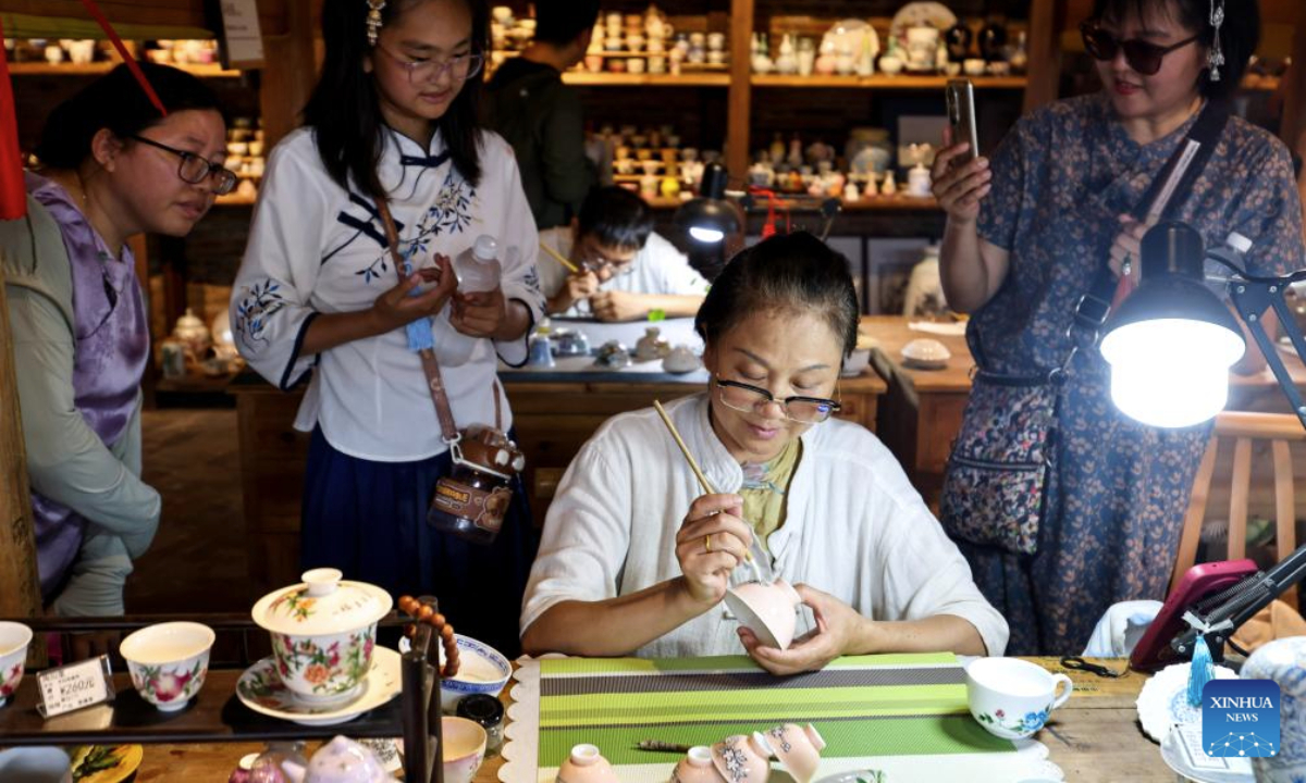 An artisan makes a ceramic product in Taoyangli historical and cultural block in Jingdezhen City, east China's Jiangxi Province, July 13, 2025. Located in the heart of Jingdezhen, Taoyangli has successfully transformed from an old district into a thriving hub for cultural innovation and tourism in recent years. Today, it has become a must-visit destination for tourists. (Xinhua/Liu Jinhai)