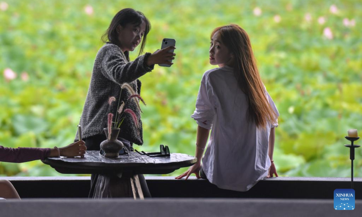 Tourists pose for photos at a coffee shop at the Puzhehei scenic area in Qiubei County, Wenshan Zhuang and Miao Autonomous Prefecture, southwest China's Yunnan Province, July 15, 2025. The beautiful scenery of Puzhehei, along with the rich amusement facilities there, has attracted lots of visitors during the summer. (Photo by Peng Yikai/Xinhua)