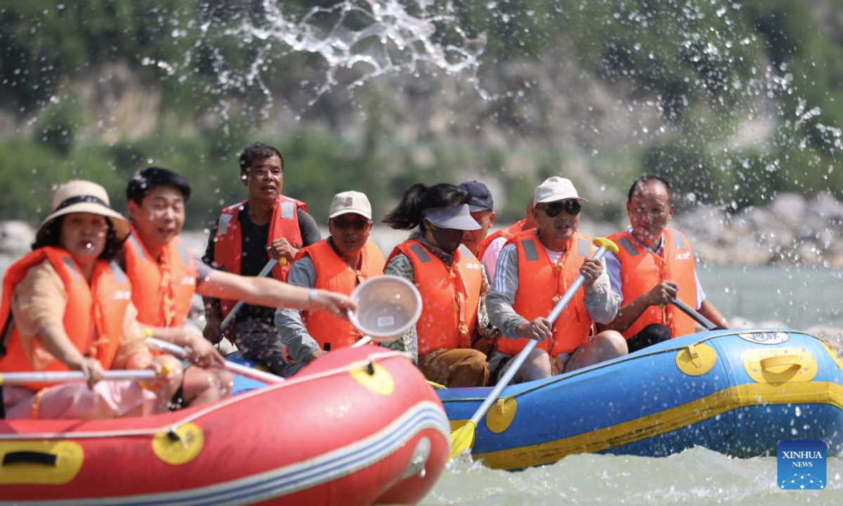 People raft in inflatable boats on Jiangling River in Huixian County, northwest China's Gansu Province, July 15, 2025. (Xinhua/Chen Bin)